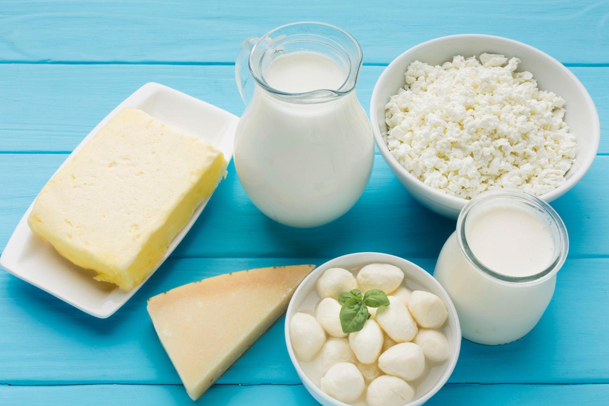 A top-view arrangement of milk, cheese, and curd showcasing calcium-rich foods essential for dental health.